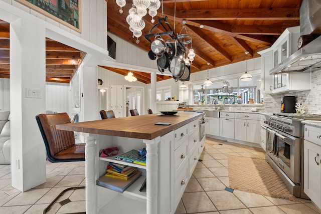 1400 Parkland Blvd, Fort Pierce, FL 34982 - kitchen featuring high end range, wall chimney exhaust hood, wooden ceiling, butcher block countertops, and a chandelier
