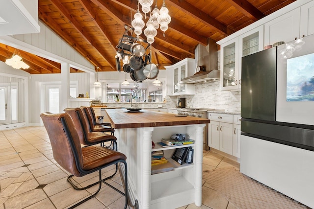 1400 Parkland Blvd, Fort Pierce, FL 34982 - kitchen with freestanding refrigerator, butcher block counters, wall chimney exhaust hood, wooden ceiling, and light tile patterned floors