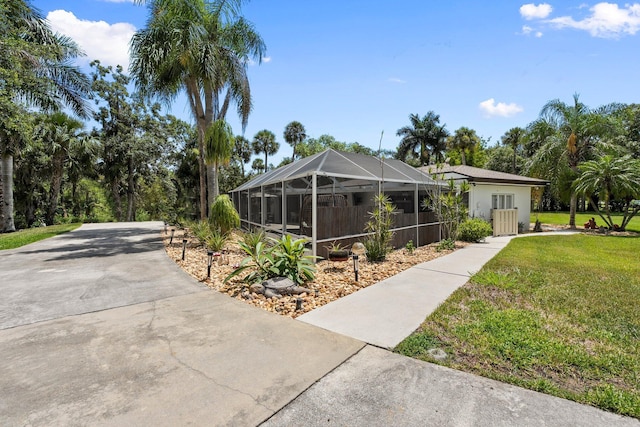 1400 Parkland Blvd, Fort Pierce, FL 34982 - view of side of home with a yard, glass enclosure, driveway, and stucco siding