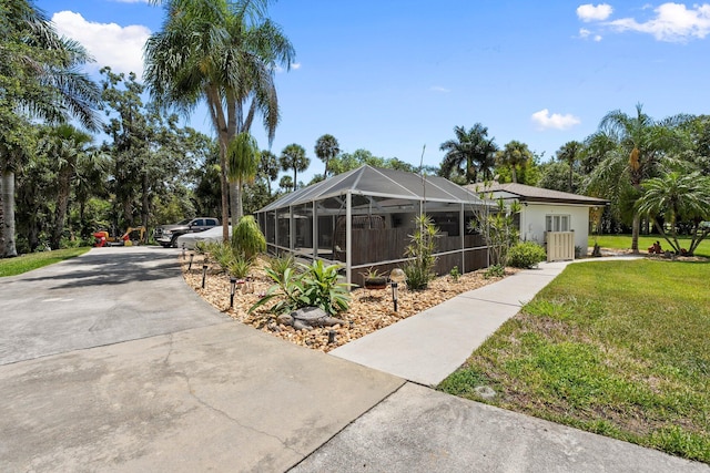 1400 Parkland Blvd, Fort Pierce, FL 34982 - view of home's exterior featuring driveway, a yard, glass enclosure, and stucco siding