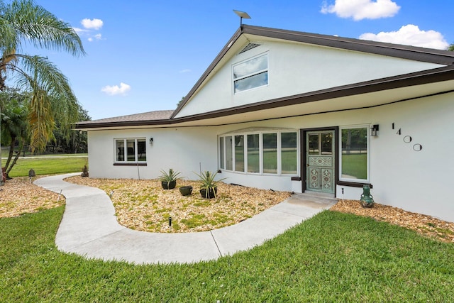 1400 Parkland Blvd, Fort Pierce, FL 34982 - back of property with stucco siding and a yard