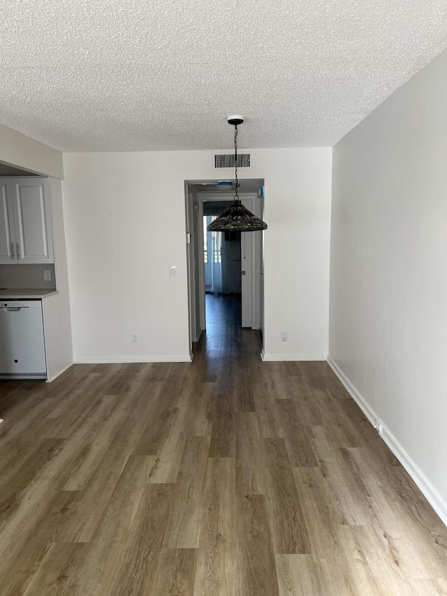 2072 Cornwall D, Boca Raton, FL 33434 - unfurnished dining area featuring a textured ceiling and dark wood-style flooring