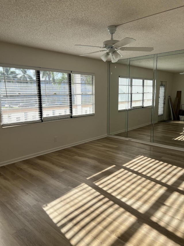 2072 Cornwall D, Boca Raton, FL 33434 - spare room featuring a textured ceiling, plenty of natural light, a ceiling fan, and wood finished floors