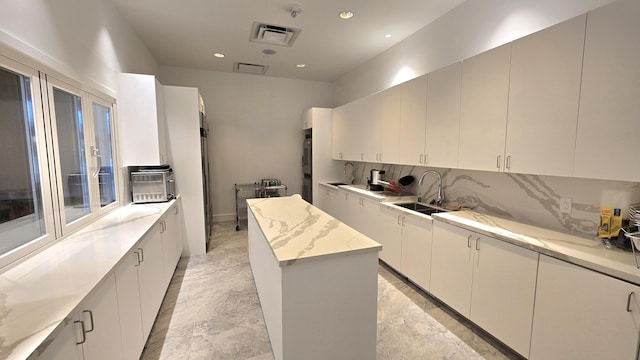 6140 Stanley Ln, Delray Beach, FL 33484 - kitchen featuring backsplash, recessed lighting, a kitchen island, light stone counters, and double wall oven