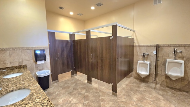 6140 Stanley Ln, Delray Beach, FL 33484 - bathroom with tile walls, a bidet, wainscoting, double vanity, and tile patterned floors