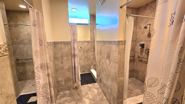6140 Stanley Ln, Delray Beach, FL 33484 - bathroom with a tile shower, recessed lighting, tile walls, and wainscoting