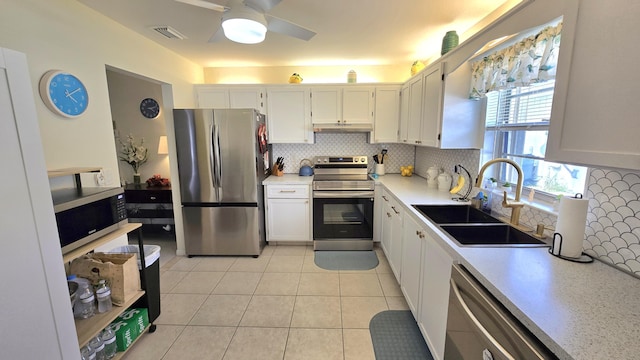 6140 Stanley Ln, Delray Beach, FL 33484 - kitchen with appliances with stainless steel finishes, under cabinet range hood, decorative backsplash, a ceiling fan, and light countertops