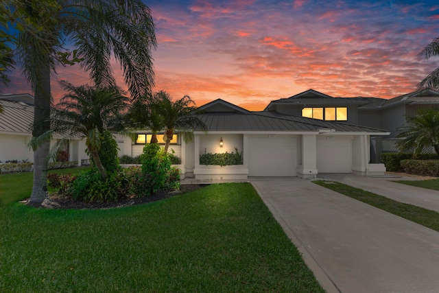 5623 SE Foxcross Pl, Stuart, FL 34997 - view of front of house featuring a standing seam roof, an attached garage, driveway, a metal roof, and a yard
