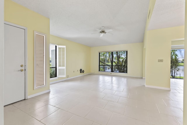 5623 SE Foxcross Pl, Stuart, FL 34997 - spare room with a ceiling fan, healthy amount of natural light, light tile patterned flooring, and a textured ceiling