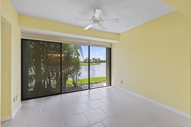 5623 SE Foxcross Pl, Stuart, FL 34997 - spare room with a water view, a textured ceiling, a ceiling fan, and tile patterned floors