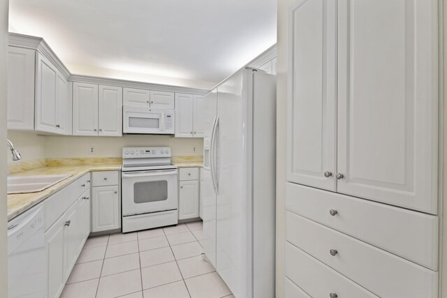 5623 SE Foxcross Pl, Stuart, FL 34997 - kitchen with white appliances, light tile patterned flooring, light countertops, and white cabinets