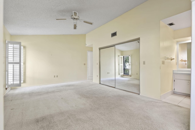 5623 SE Foxcross Pl, Stuart, FL 34997 - unfurnished bedroom featuring vaulted ceiling, light colored carpet, a closet, a textured ceiling, and ensuite bathroom