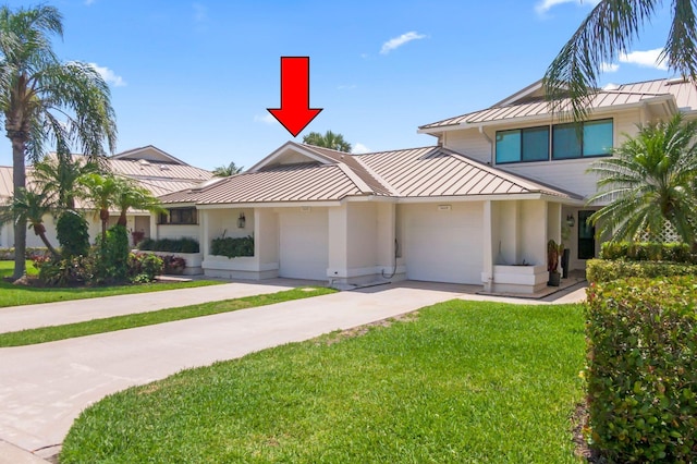 5623 SE Foxcross Pl, Stuart, FL 34997 - view of front of house featuring a standing seam roof, a metal roof, driveway, an attached garage, and a front lawn
