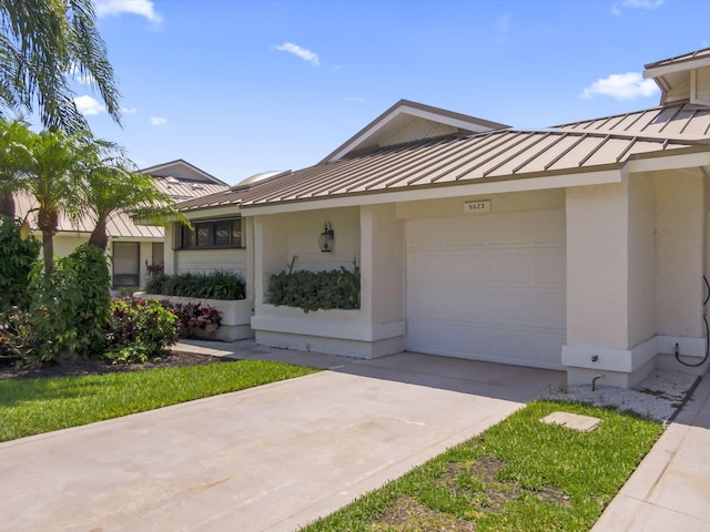 5623 SE Foxcross Pl, Stuart, FL 34997 - view of front of home featuring a standing seam roof, a metal roof, an attached garage, and stucco siding