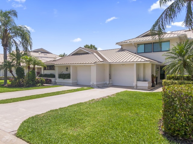 5623 SE Foxcross Pl, Stuart, FL 34997 - view of front of house with a standing seam roof, a metal roof, concrete driveway, a front yard, and a garage