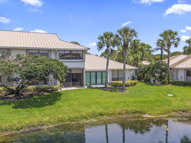 5623 SE Foxcross Pl, Stuart, FL 34997 - back of house featuring a standing seam roof, a metal roof, a yard, a water view, and stucco siding