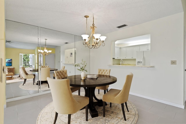 5623 SE Foxcross Pl, Stuart, FL 34997 - dining space featuring a chandelier, a textured ceiling, and light tile patterned floors