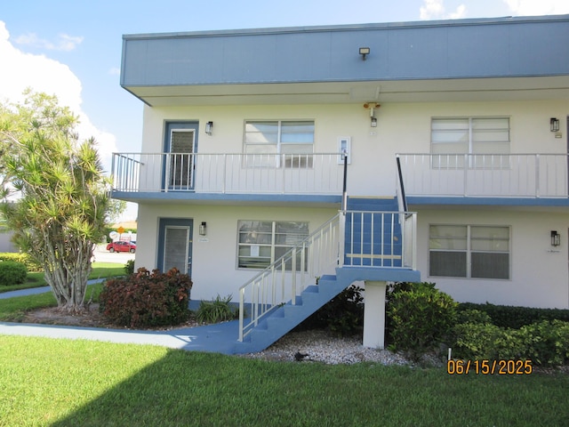 241 Normandy F, Delray Beach, FL 33484 - view of front of home featuring stairs, a front lawn, and stucco siding