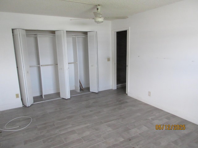 241 Normandy F, Delray Beach, FL 33484 - unfurnished bedroom with multiple closets, wood finished floors, and a ceiling fan