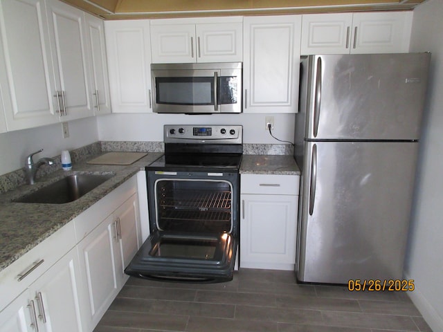 241 Normandy F, Delray Beach, FL 33484 - kitchen featuring stainless steel appliances, white cabinetry, and wood tiled floors