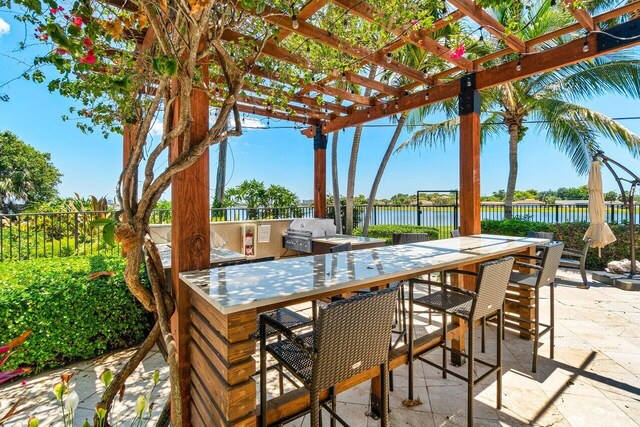 1830 Embassy Dr Unit 401, West Palm Beach, FL 33401 - view of patio / terrace with area for grilling, a water view, and a pergola