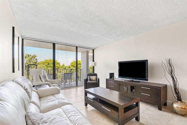 1830 Embassy Dr Unit 401, West Palm Beach, FL 33401 - living area featuring light tile patterned floors, a wall of windows, and a textured ceiling