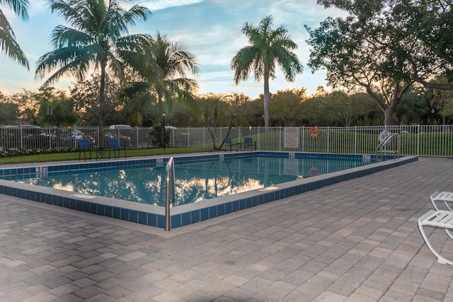 120 Sparrow Dr Unit 302, Royal Palm Beach, FL 33411 - pool at dusk featuring a community pool and a patio area