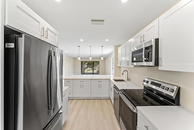 23 Stratford Dr Unit H, Boynton Beach, FL 33436 - kitchen with stainless steel appliances, white cabinets, light wood-type flooring, light countertops, and recessed lighting