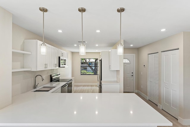 23 Stratford Dr Unit H, Boynton Beach, FL 33436 - kitchen featuring appliances with stainless steel finishes, open shelves, light countertops, recessed lighting, and light wood-type flooring