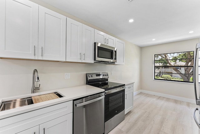 23 Stratford Dr Unit H, Boynton Beach, FL 33436 - kitchen with stainless steel appliances, light countertops, recessed lighting, white cabinets, and light wood-type flooring
