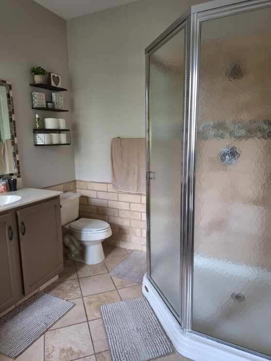 3172 N Greenleaf Cir, Boynton Beach, FL 33426 - bathroom featuring vanity, a shower stall, tile patterned floors, and wainscoting
