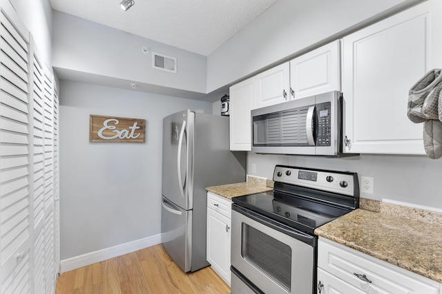 2218 Tuscany Way, Boynton Beach, FL 33435 - kitchen with appliances with stainless steel finishes, light wood-style floors, white cabinetry, light stone counters, and a textured ceiling