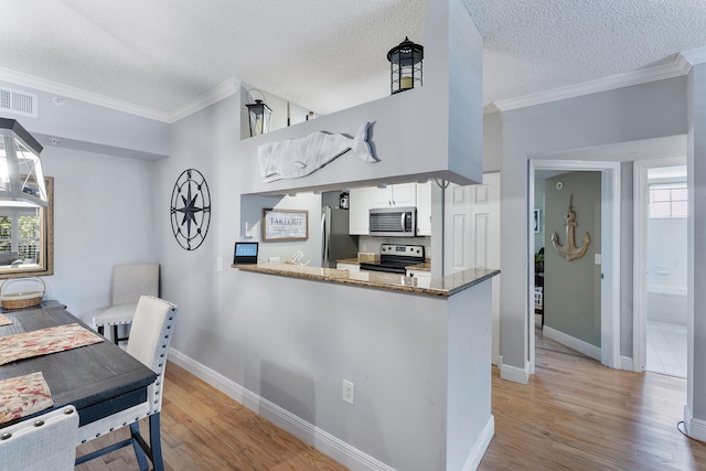 2218 Tuscany Way, Boynton Beach, FL 33435 - kitchen featuring appliances with stainless steel finishes, crown molding, light wood-style floors, dark stone counters, and white cabinetry