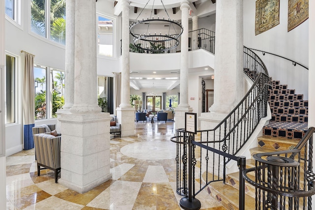 2218 Tuscany Way, Boynton Beach, FL 33435 - entryway featuring ornate columns, a high ceiling, stairway, marble tiled floors, and a chandelier