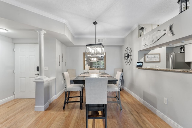 2218 Tuscany Way, Boynton Beach, FL 33435 - dining space featuring decorative columns, light wood-type flooring, crown molding, and a textured ceiling