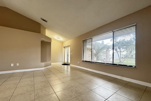 610 SE Forgal St, Port Saint Lucie, FL 34983 - spare room with lofted ceiling, light tile patterned floors, and a textured ceiling