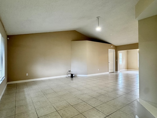 610 SE Forgal St, Port Saint Lucie, FL 34983 - empty room featuring light tile patterned flooring, vaulted ceiling, and a textured ceiling