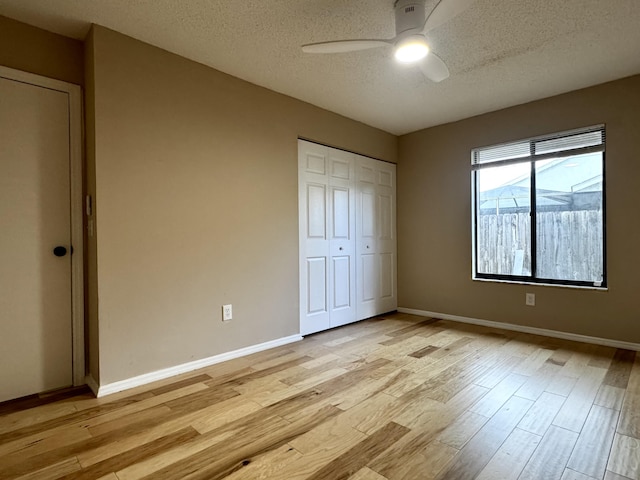 610 SE Forgal St, Port Saint Lucie, FL 34983 - unfurnished bedroom featuring a textured ceiling, light wood-style flooring, a closet, and a ceiling fan