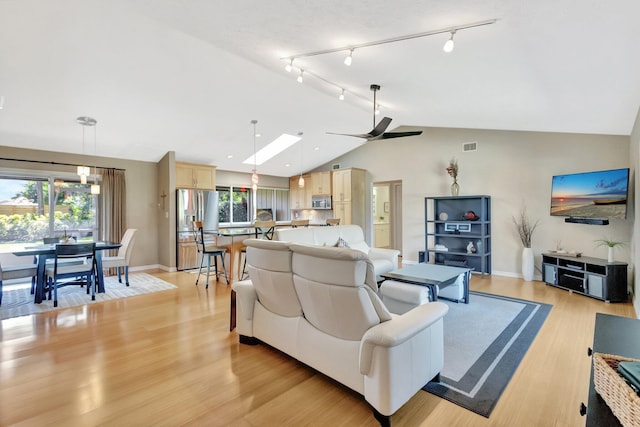 1434 SE Kirke Ln, Port Saint Lucie, FL 34983 - living area with vaulted ceiling, healthy amount of natural light, ceiling fan, rail lighting, and a skylight