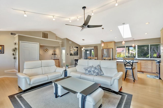 1434 SE Kirke Ln, Port Saint Lucie, FL 34983 - living area featuring track lighting, vaulted ceiling, light wood-style floors, a ceiling fan, and a skylight