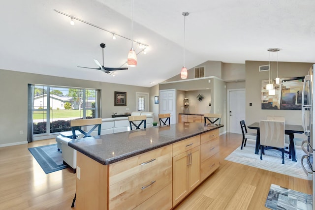 1434 SE Kirke Ln, Port Saint Lucie, FL 34983 - kitchen featuring light brown cabinets, vaulted ceiling, light wood-type flooring, rail lighting, and a kitchen island