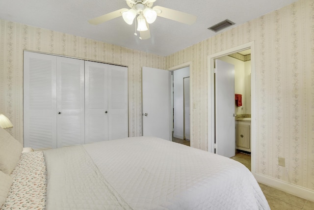 968 Sumter Rd W, West Palm Beach, FL 33415 - bedroom with wallpapered walls, light tile patterned flooring, a closet, ensuite bathroom, and ceiling fan