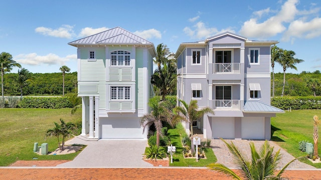 4917 Watersong Way, Fort Pierce, FL 34949 - beach home featuring decorative driveway, a garage, a balcony, a standing seam roof, and a front yard