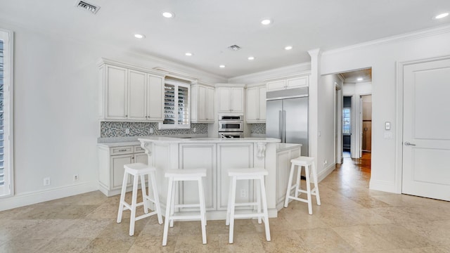 4917 Watersong Way, Fort Pierce, FL 34949 - kitchen with stainless steel built in fridge, ornamental molding, light countertops, backsplash, and a kitchen island