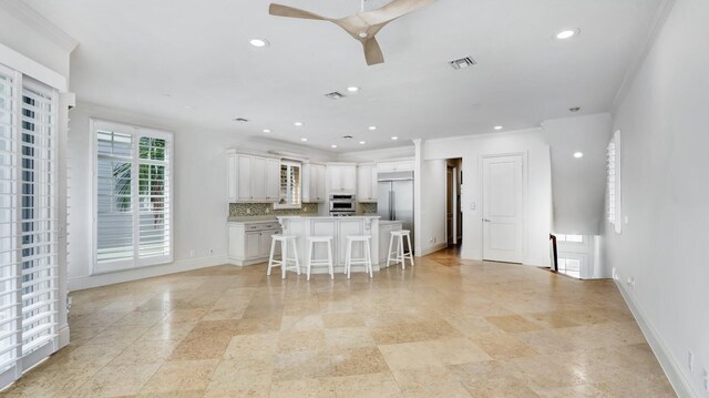 4917 Watersong Way, Fort Pierce, FL 34949 - kitchen with stainless steel appliances, a kitchen breakfast bar, white cabinets, light countertops, and a ceiling fan