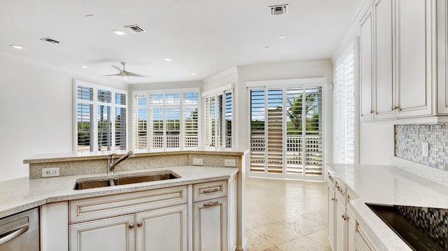 4917 Watersong Way, Fort Pierce, FL 34949 - kitchen with black electric stovetop, dishwasher, a ceiling fan, backsplash, and light stone counters