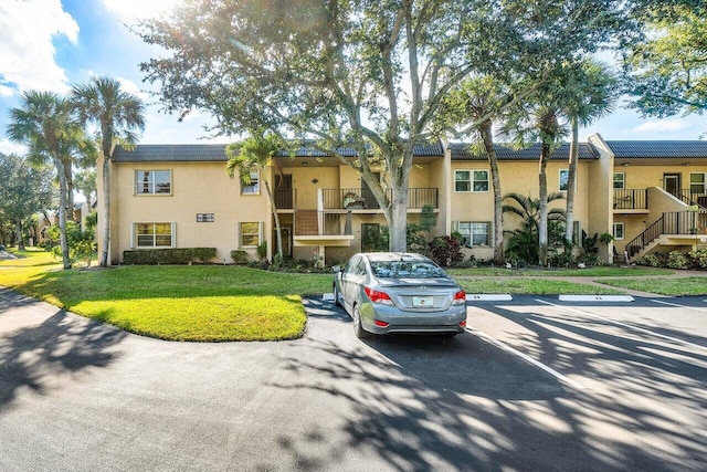 148 Lake Constance Dr Unit 148, West Palm Beach, FL 33411 - view of building exterior with uncovered parking and stairway