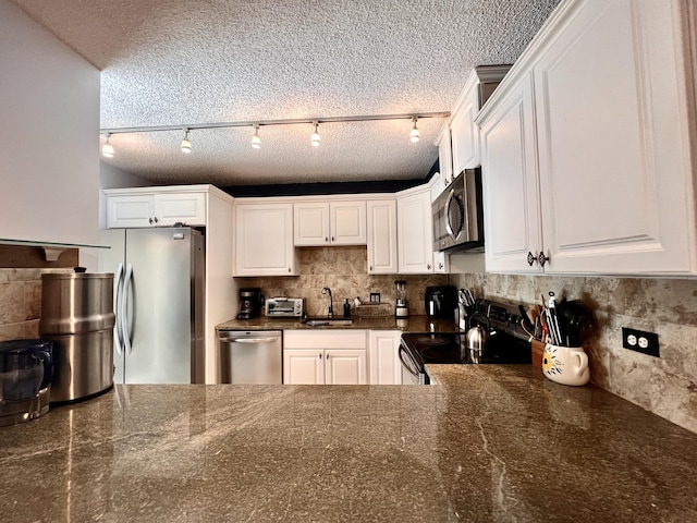 1535 Masters Cir Unit 148, Delray Beach, FL 33445 - kitchen with stainless steel appliances, white cabinets, decorative backsplash, a textured ceiling, and dark stone counters