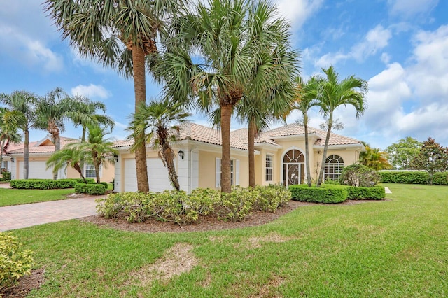 8851 Oldham Way, Palm Beach Gardens, FL 33412 - mediterranean / spanish-style home with a tile roof, stucco siding, a garage, a front yard, and decorative driveway