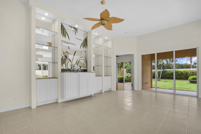 8851 Oldham Way, Palm Beach Gardens, FL 33412 - unfurnished living room with built in features, healthy amount of natural light, light tile patterned floors, ceiling fan, and recessed lighting